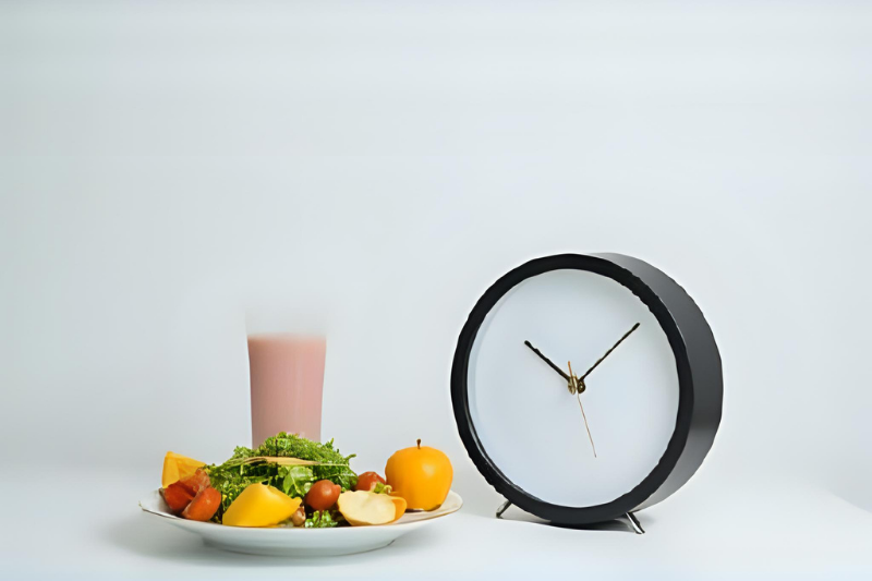 Intermittent fasting concept with clock and healthy food for weight loss